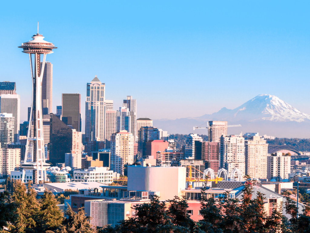 A clear view of the Space Needle, city buildings, and snow-capped Mount Rainier