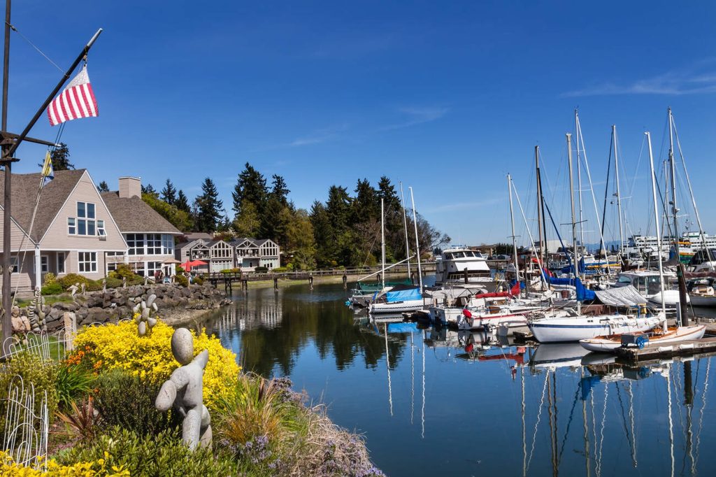 Charming marina with sailboats docked near waterfront homes, a peaceful coastal stop featured in this Seattle travel guide.