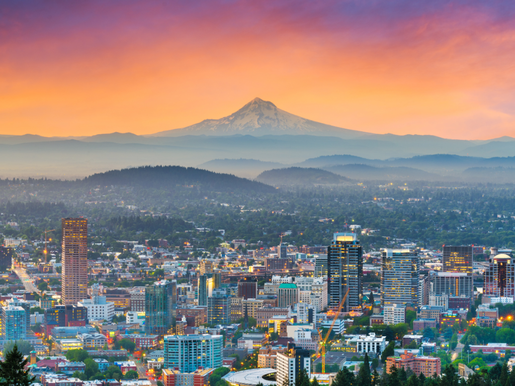 Portland skyline at sunset with Mount Hood rising in the distance, highlighting popular things to do in Portland Oregon for visitors
