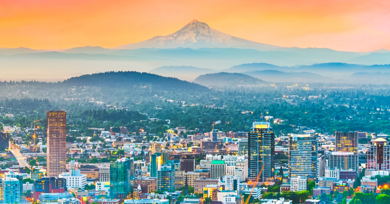 Portland skyline at sunset with Mount Hood rising in the distance, highlighting popular things to do in Portland Oregon for visitors
