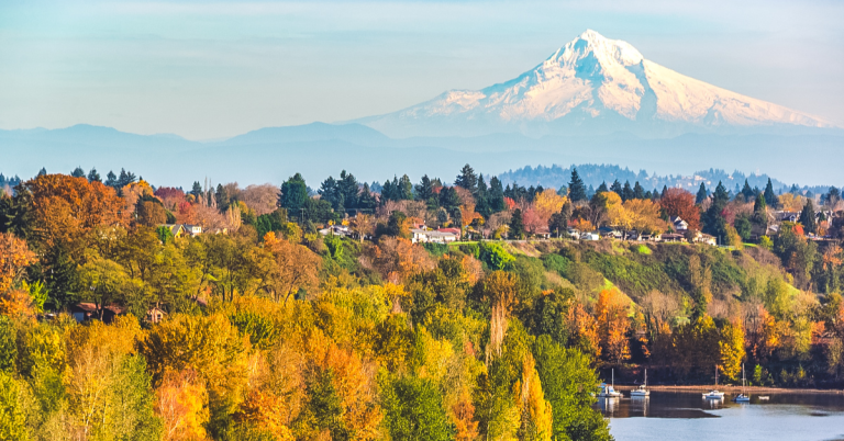 Autumn trees along a river with Mount Hood rising in the background, showcasing one of the scenic things to see near Portland