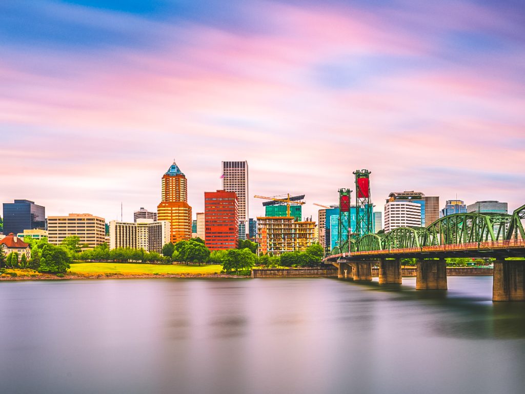 Downtown Portland Oregon skyline along the Willamette River with the Hawthorne Bridge at sunset