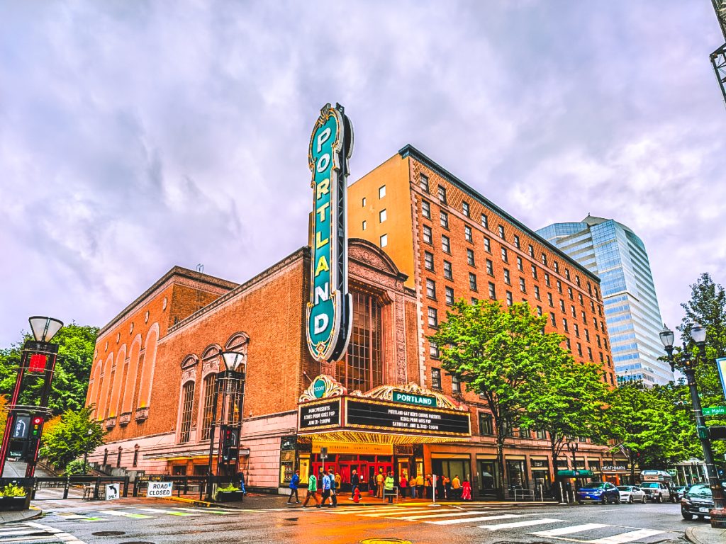 The Arlene Schnitzer Concert Hall with its iconic Portland marquee and people crossing the street in downtown Portland