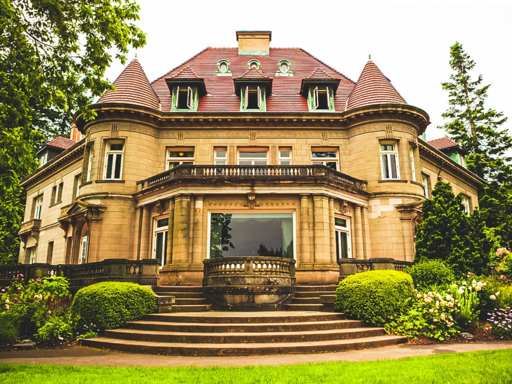 Pittock Mansion overlooking Portland with historic stone architecture, manicured gardens, and turreted roof