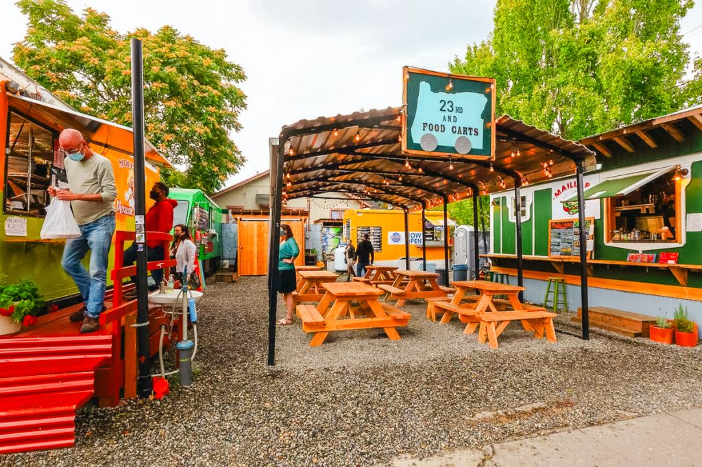 Outdoor food cart pod with picnic tables and colorful food trucks in Portland featured in a 3 days in Portland Oregon itinerary