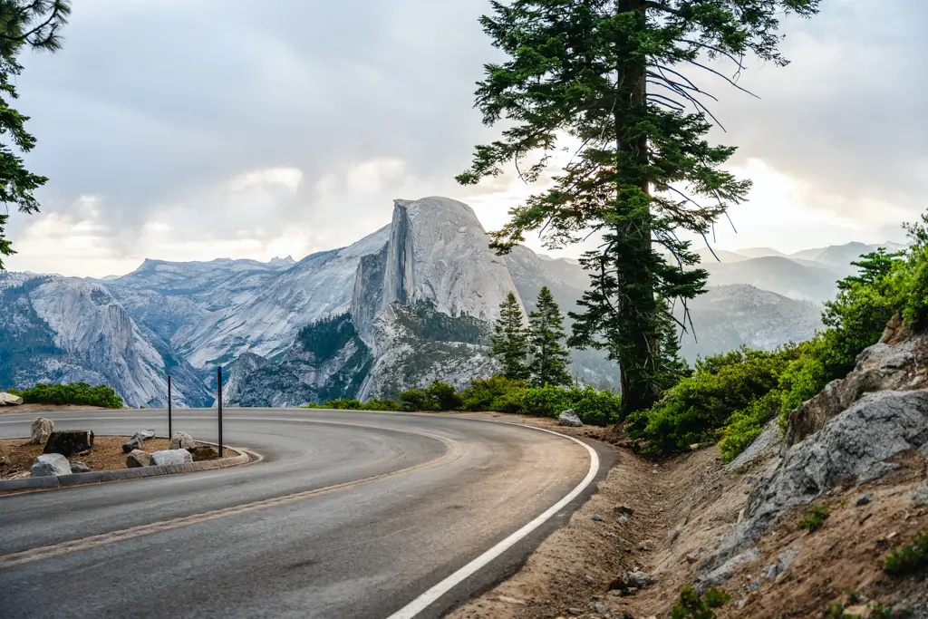 The winding road to Glacier Point overlooks Half Dome in Yosemite National Park. This iconic viewpoint is accessible by car during the summer months and offers one of the park's most breathtaking panoramic views.