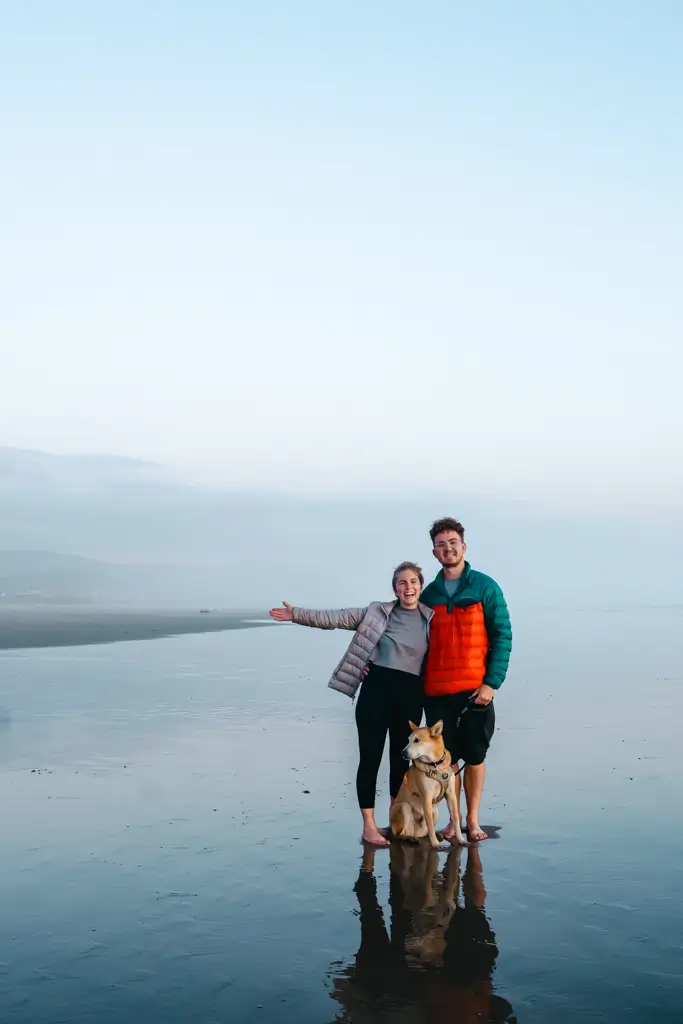 Wearing an REI puffy jacket on the Oregon Coast during a cool morning with ocean views and a dog on the beach.