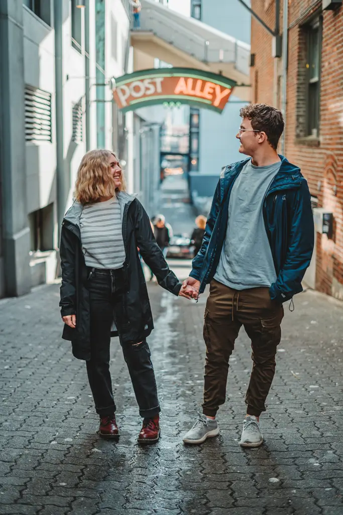 Wearing an REI rain jacket while exploring Seattle's iconic Post Alley on a rainy day.
