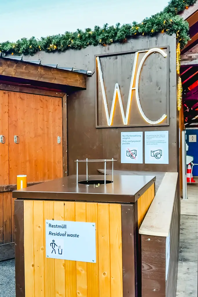 WC sign for the public restrooms at the Rathausplatz Christmas Market in Vienna, Austria, with signs noting card-only payment.