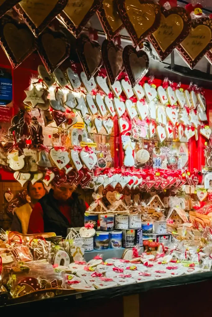 Traditional decorated MedovnÃky gingerbread cookies hanging in heart, star, and holiday shapes at a festive European Christmas market stall.